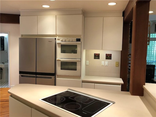 5015 Wright Bridge Rd, Cumming, GA 30028 - kitchen with black electric cooktop, white double oven, freestanding refrigerator, light countertops, and recessed lighting