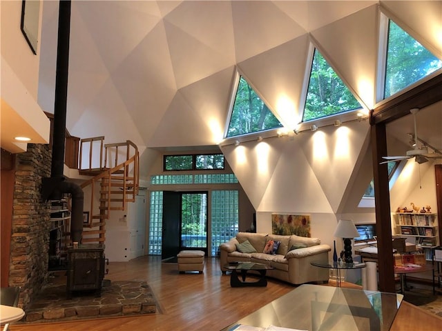 5015 Wright Bridge Rd, Cumming, GA 30028 - living area with a towering ceiling, a wood stove, wood finished floors, a ceiling fan, and stairs