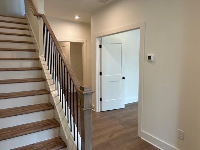 stairway with baseboards, wood finished floors, and recessed lighting