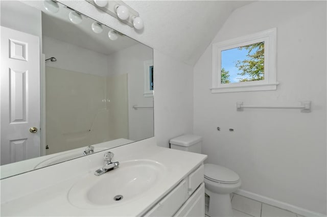 bathroom featuring lofted ceiling, vanity, tile patterned floors, toilet, and walk in shower