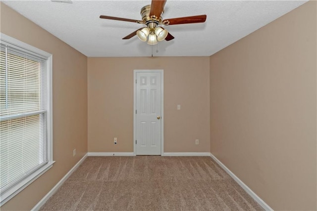 carpeted empty room featuring a textured ceiling and ceiling fan