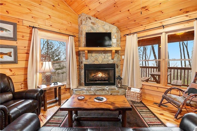 living room with plenty of natural light, vaulted ceiling, and wood walls