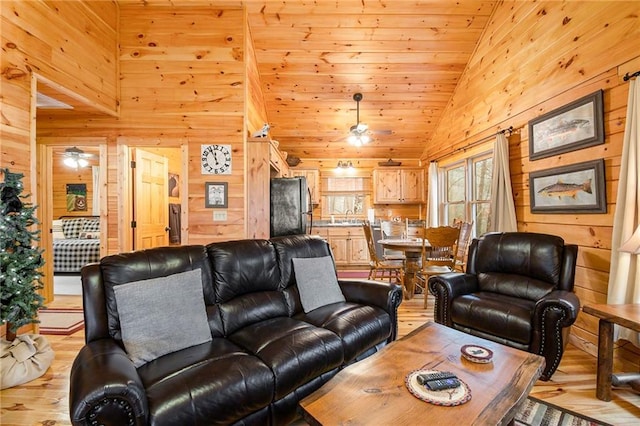 living room with sink, wood ceiling, high vaulted ceiling, light hardwood / wood-style flooring, and wooden walls