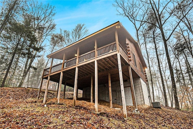 rear view of house featuring a wooden deck and central air condition unit