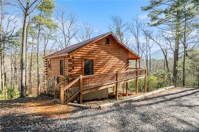 log cabin with a wooden deck