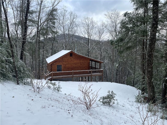 view of snowy exterior with a wooden deck