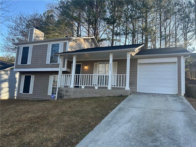 split level home with a garage, a front yard, and covered porch