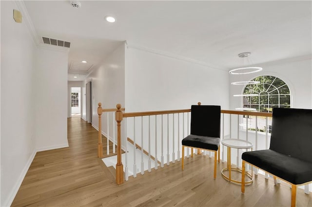 hall featuring ornamental molding, a chandelier, and hardwood / wood-style floors