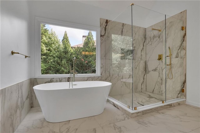 bathroom featuring tile walls, independent shower and bath, and a healthy amount of sunlight