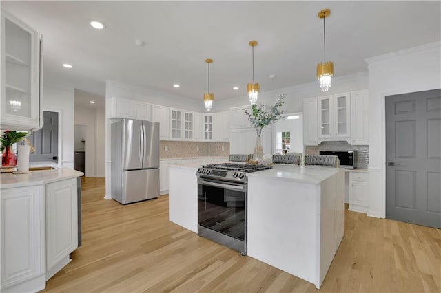 kitchen with light hardwood / wood-style flooring, white cabinetry, and appliances with stainless steel finishes