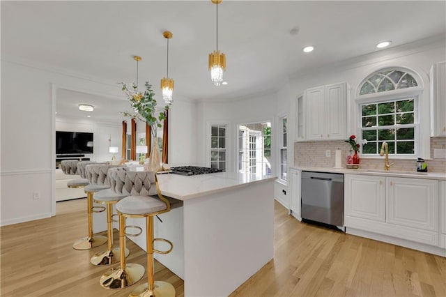 kitchen featuring white cabinets, pendant lighting, light hardwood / wood-style flooring, backsplash, and stainless steel appliances