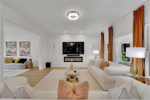 living room with light wood-type flooring and crown molding