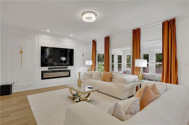 living room with light hardwood / wood-style floors and ornamental molding