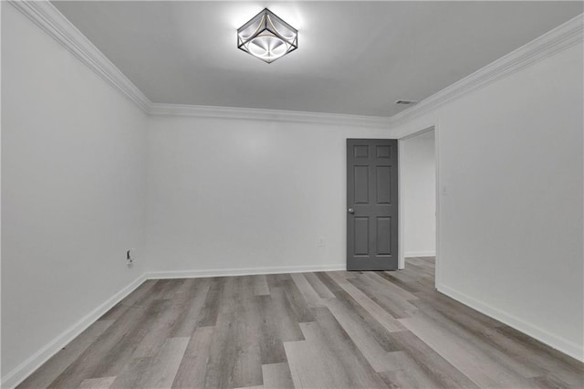 spare room with crown molding and light hardwood / wood-style flooring