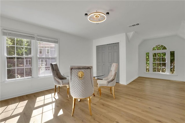 dining area with light hardwood / wood-style floors and vaulted ceiling