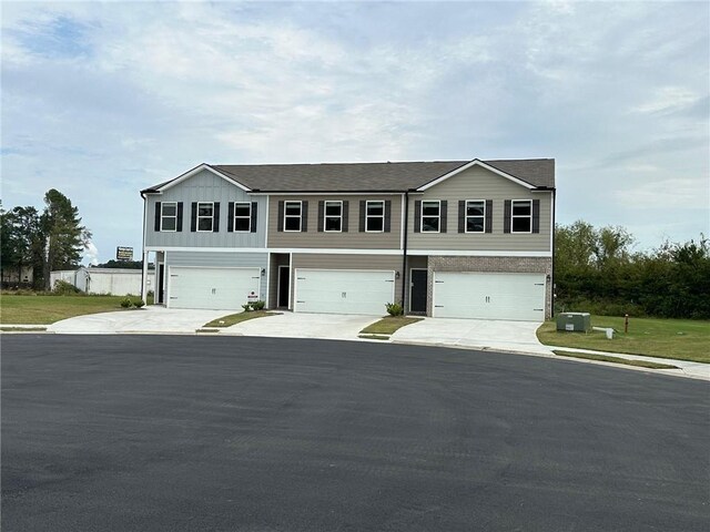 view of property featuring an attached garage and concrete driveway