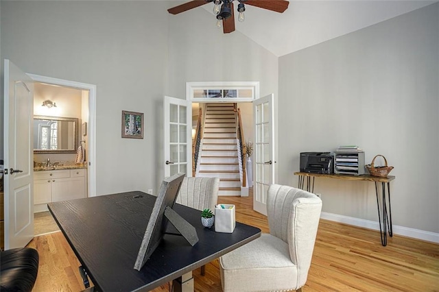 office space with ceiling fan, french doors, sink, high vaulted ceiling, and light hardwood / wood-style floors