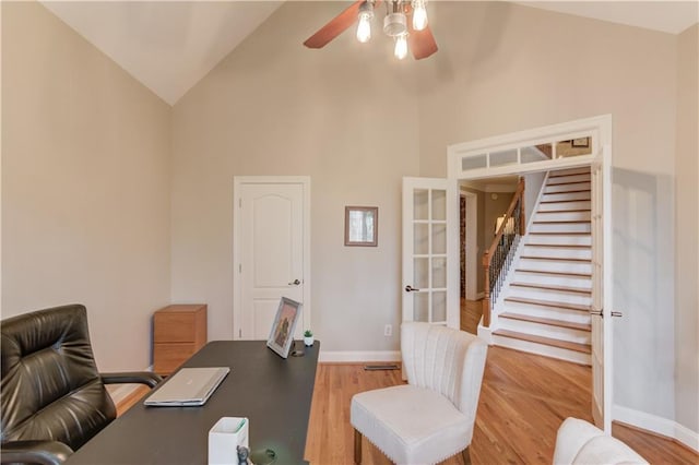 dining room with ceiling fan, a stone fireplace, crown molding, vaulted ceiling, and light wood-type flooring