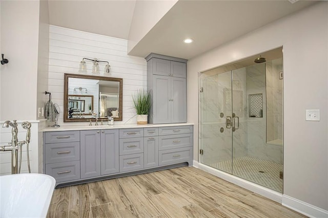 bathroom with independent shower and bath, wooden walls, vanity, and wood-type flooring