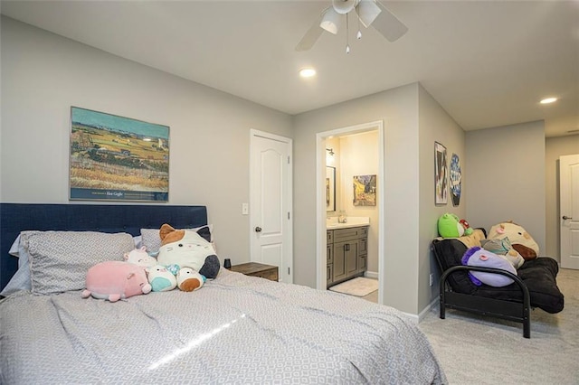 bedroom featuring light carpet, ensuite bath, and ceiling fan