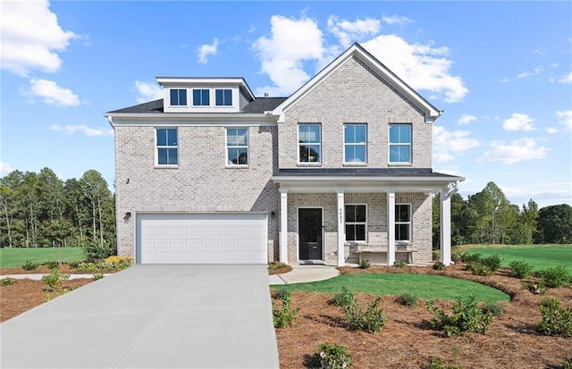 view of front of property with concrete driveway, brick siding, an attached garage, and a front yard