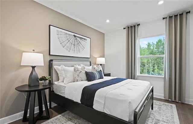 bedroom featuring baseboards, wood finished floors, and recessed lighting