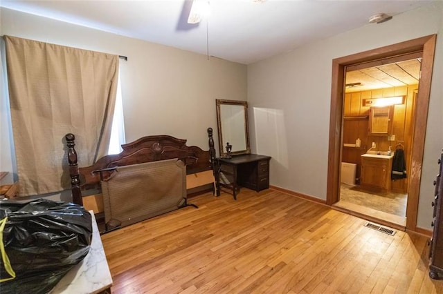 bedroom featuring connected bathroom, ceiling fan, and light wood-type flooring