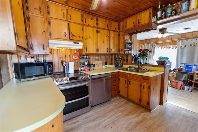 kitchen featuring appliances with stainless steel finishes, sink, ceiling fan, kitchen peninsula, and light hardwood / wood-style flooring