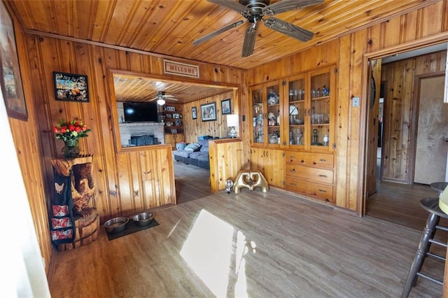 dining room with dark hardwood / wood-style floors, ceiling fan, a fireplace, and wooden ceiling