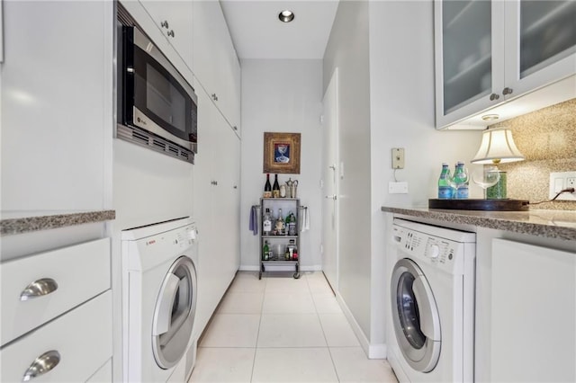 clothes washing area featuring washer / dryer and light tile patterned floors