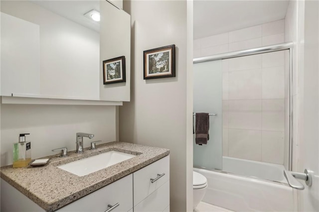 full bathroom featuring vanity, enclosed tub / shower combo, and toilet