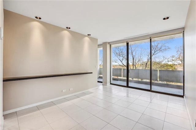 empty room with light tile patterned flooring and a water view