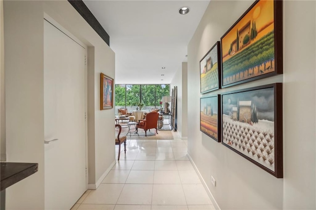 corridor featuring a wall of windows and light tile patterned flooring