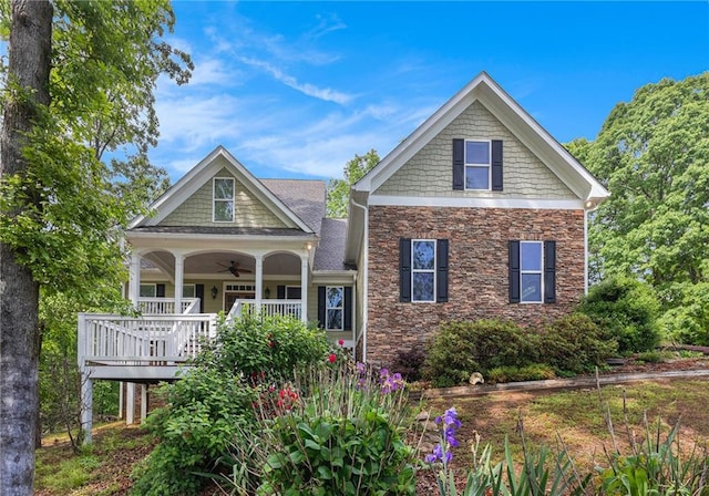 craftsman-style home with a porch, stone siding, and ceiling fan