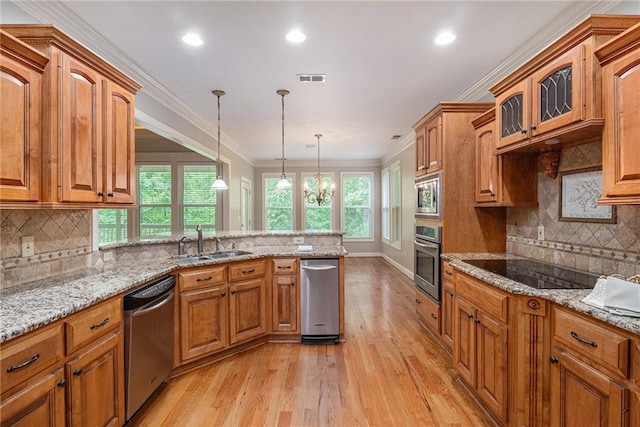 kitchen featuring stainless steel appliances, a sink, light wood finished floors, decorative backsplash, and recessed lighting