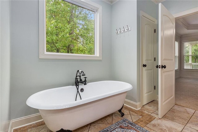 full bath with a freestanding bath, baseboards, and ornamental molding