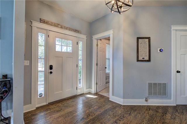 foyer with dark hardwood / wood-style floors and a chandelier