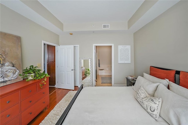 bedroom with connected bathroom and light hardwood / wood-style floors