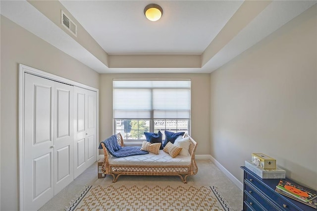 sitting room with light carpet and a tray ceiling