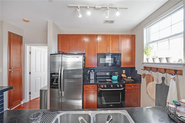 kitchen featuring black appliances and tasteful backsplash