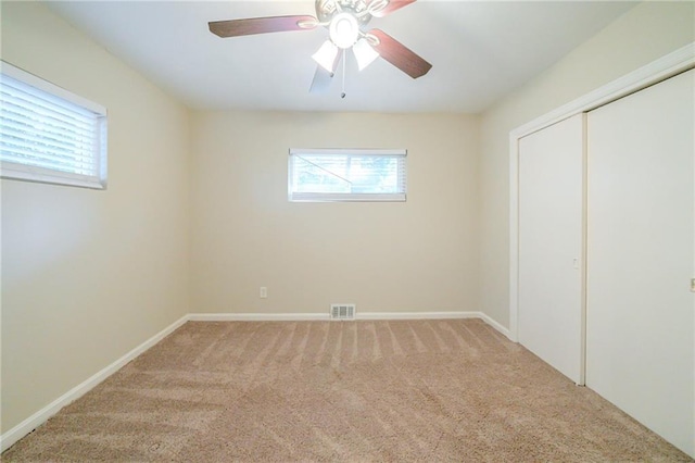 unfurnished bedroom with carpet floors, ceiling fan, and a closet