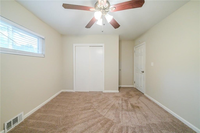 interior space featuring ceiling fan, a closet, and light carpet