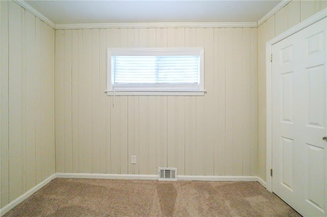 carpeted empty room featuring crown molding