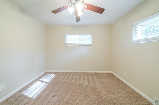 carpeted empty room featuring plenty of natural light and ceiling fan