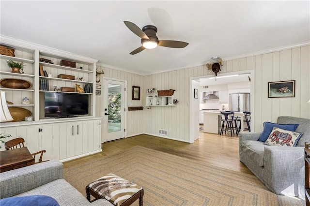 3311 Stillhouse Rd SE, Atlanta, GA 30339 - living room with crown molding, wood finished floors, a ceiling fan, and baseboards