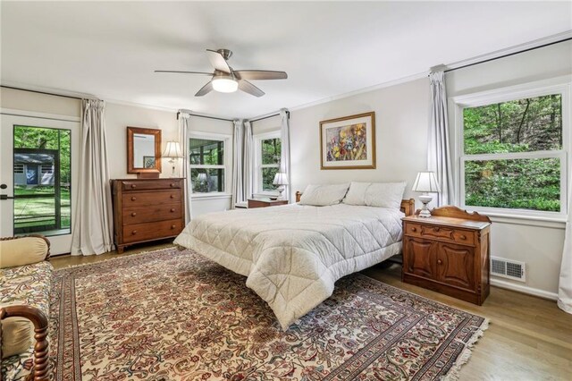 3311 Stillhouse Rd SE, Atlanta, GA 30339 - bedroom featuring multiple windows, wood finished floors, access to exterior, ceiling fan, and ornamental molding