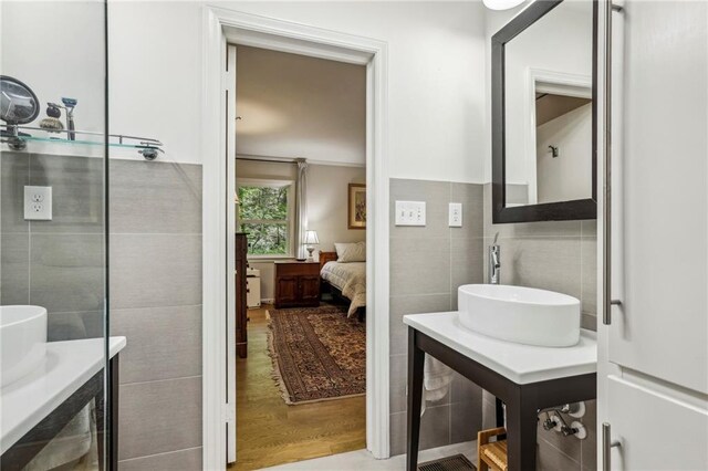 3311 Stillhouse Rd SE, Atlanta, GA 30339 - ensuite bathroom with tile walls, a sink, and wood finished floors