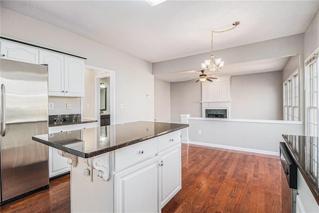 kitchen with dark hardwood / wood-style flooring, stainless steel refrigerator, white cabinets, and a kitchen island