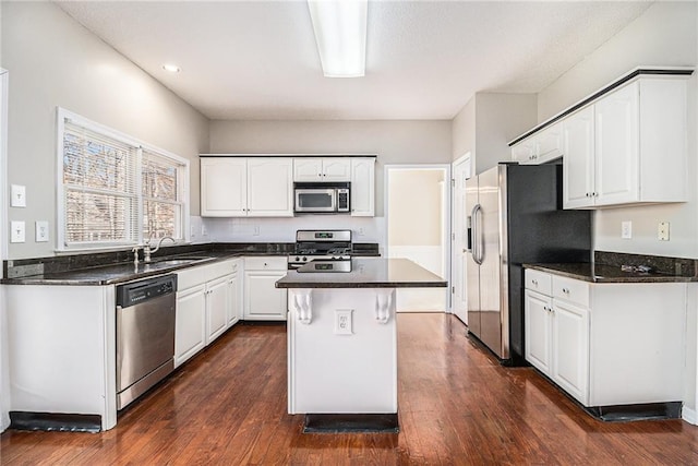 kitchen with sink, white cabinetry, a center island, dark hardwood / wood-style floors, and stainless steel appliances