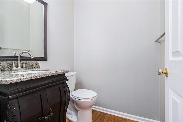 bathroom with vanity, wood-type flooring, and toilet